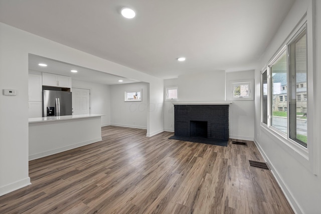 2671 Whitehead Rd, Columbus, OH 43204 - unfurnished living room featuring recessed lighting, visible vents, wood finished floors, and a fireplace