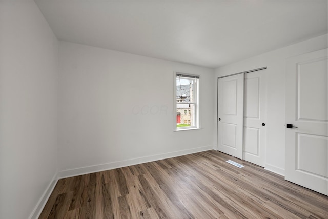 2671 Whitehead Rd, Columbus, OH 43204 - unfurnished bedroom featuring baseboards, visible vents, light wood-style flooring, and a closet