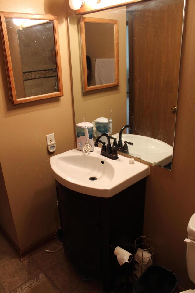 bathroom featuring toilet, tile patterned flooring, and vanity