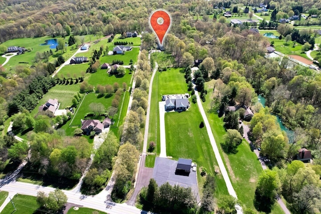 birds eye view of property featuring a water view and a forest view