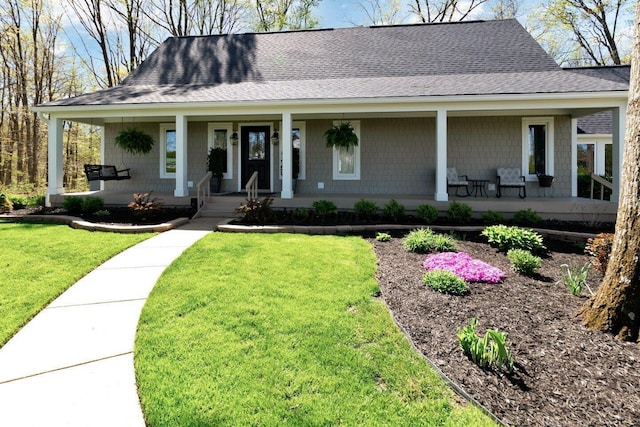 farmhouse featuring a porch, a shingled roof, and a front lawn