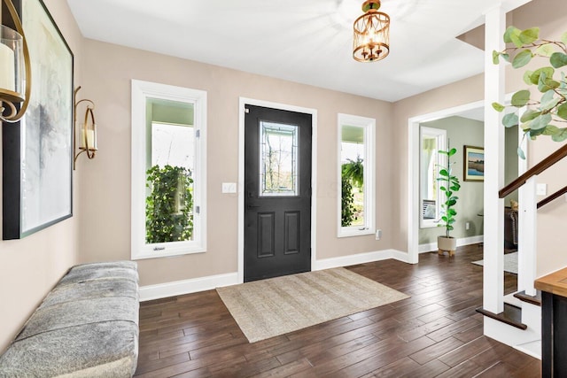 entrance foyer with baseboards, dark wood-style flooring, and stairway