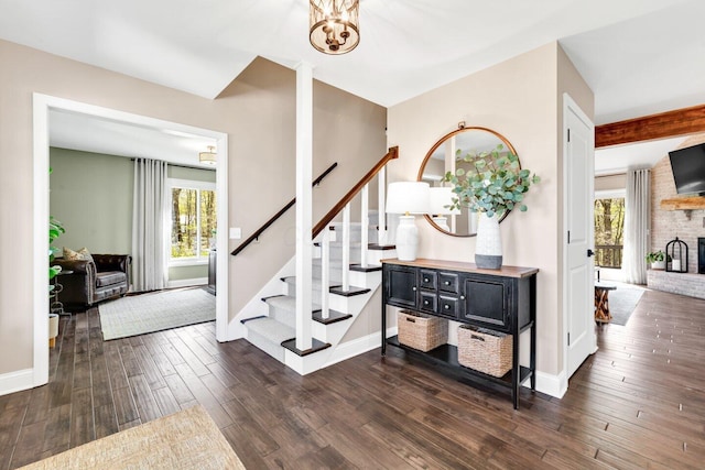 foyer entrance featuring a healthy amount of sunlight, baseboards, dark wood-style flooring, and stairs
