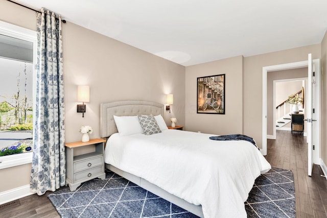 bedroom featuring baseboards, visible vents, and dark wood-type flooring