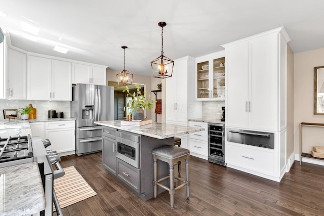 kitchen featuring glass insert cabinets, decorative backsplash, wine cooler, a warming drawer, and stainless steel appliances