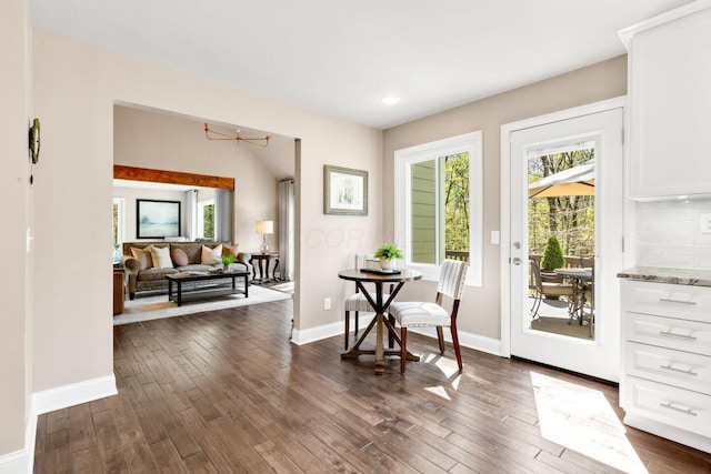 dining area featuring plenty of natural light, dark wood finished floors, and baseboards