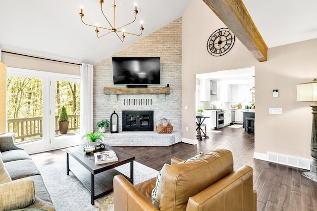 living area with a fireplace, high vaulted ceiling, a chandelier, wood finished floors, and visible vents