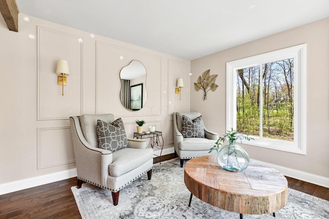 living area with baseboards and wood finished floors