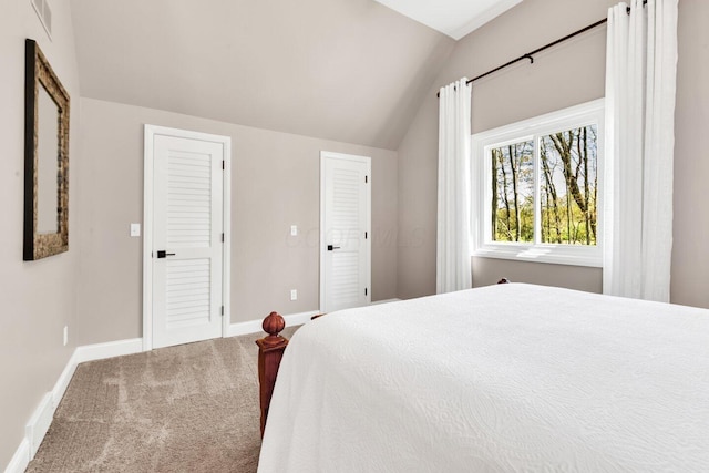 bedroom featuring visible vents, baseboards, lofted ceiling, and carpet