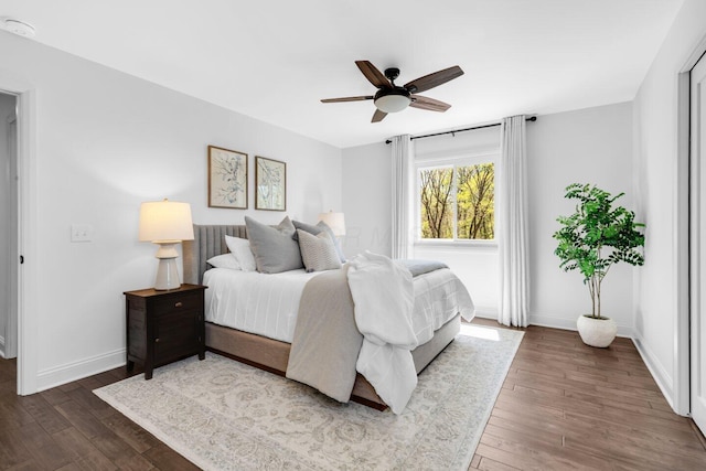 bedroom featuring baseboards, ceiling fan, and dark wood-style flooring