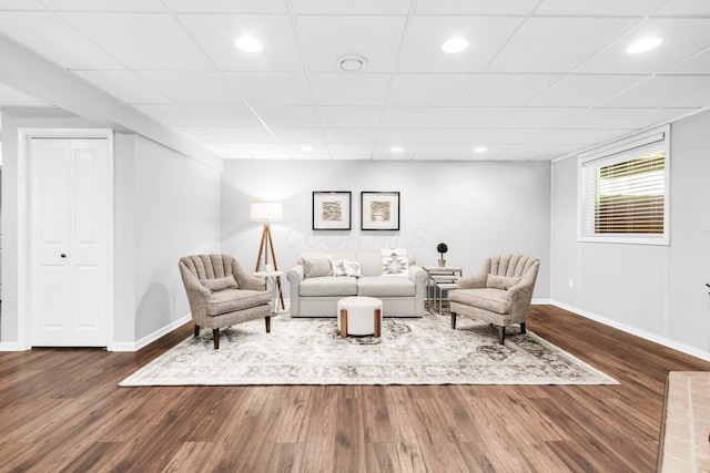 living area with baseboards, recessed lighting, a drop ceiling, and dark wood-style floors