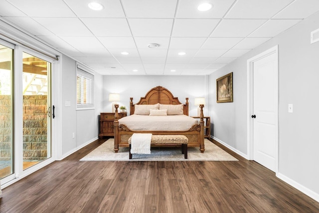 bedroom with recessed lighting, baseboards, dark wood finished floors, and a paneled ceiling