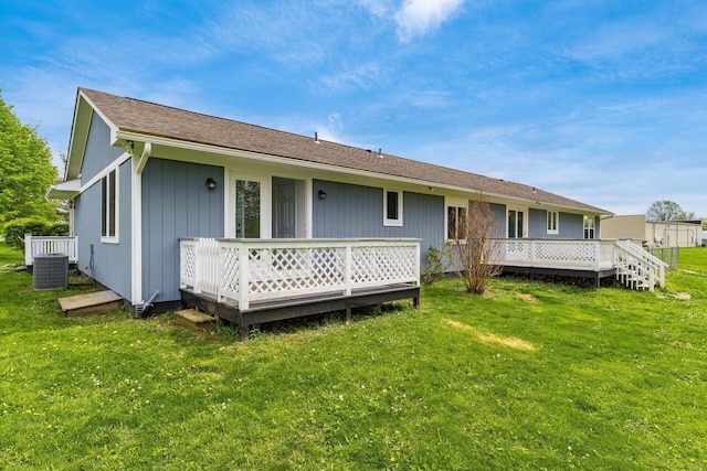 rear view of house with central AC unit, a yard, and a deck