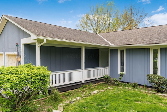 exterior space featuring roof with shingles and a front yard