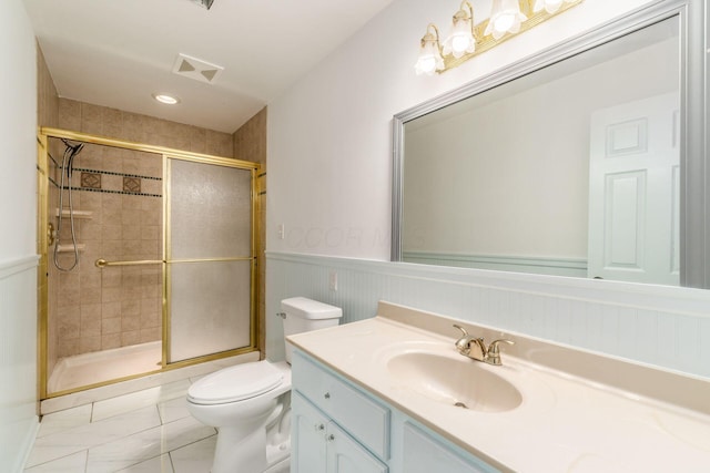 full bath with vanity, wainscoting, toilet, and a shower stall