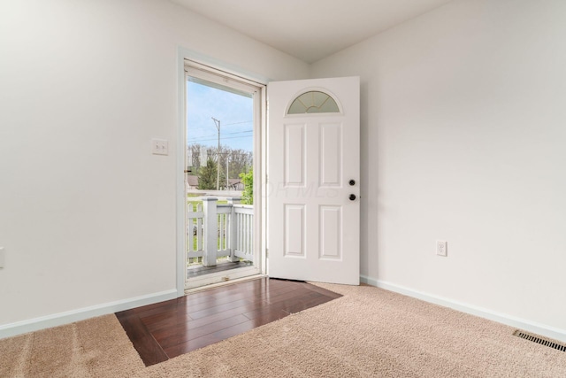 entryway featuring baseboards, visible vents, and carpet