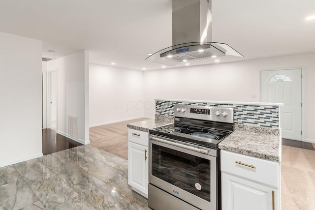 kitchen featuring white cabinets, stainless steel range with electric cooktop, baseboards, island range hood, and visible vents