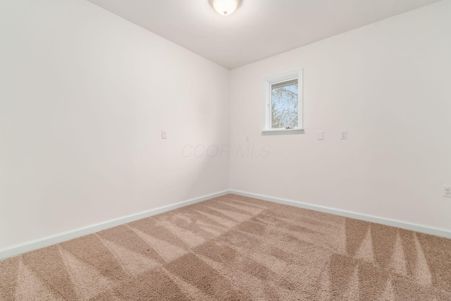 empty room featuring baseboards and carpet flooring