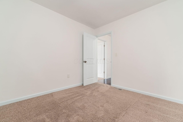 carpeted spare room with baseboards and visible vents