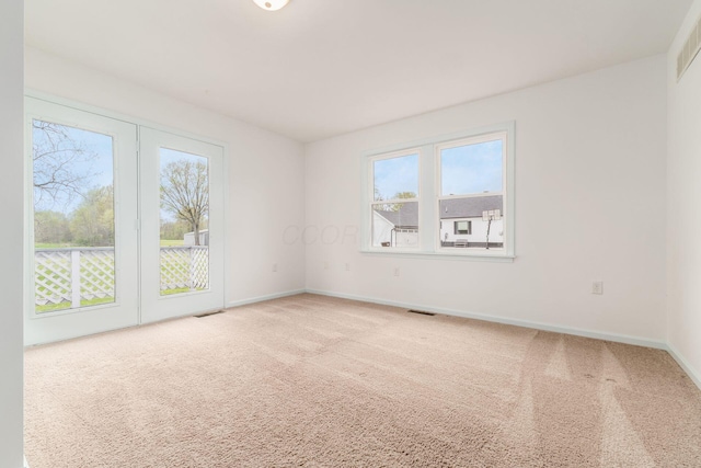 carpeted empty room with baseboards and visible vents