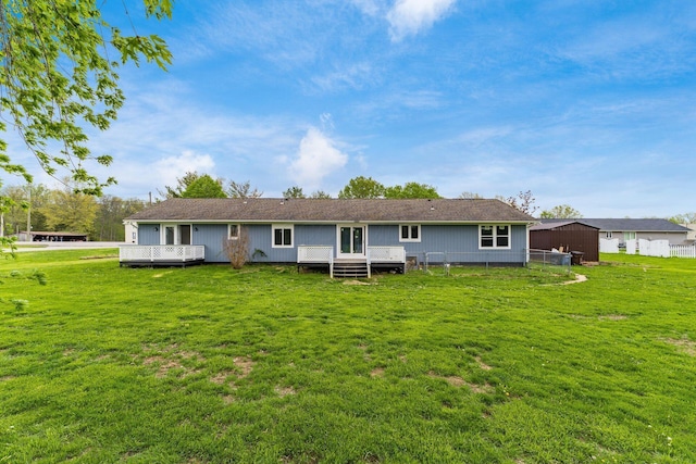 rear view of house with a wooden deck and a yard