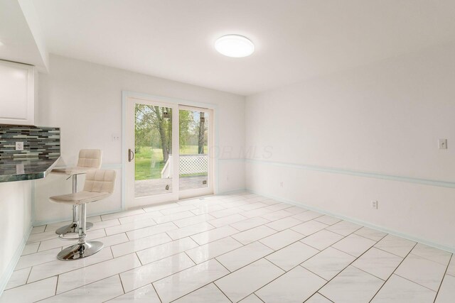 interior space featuring baseboards and light tile patterned flooring