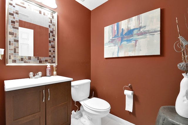 bathroom with toilet, baseboards, and vanity