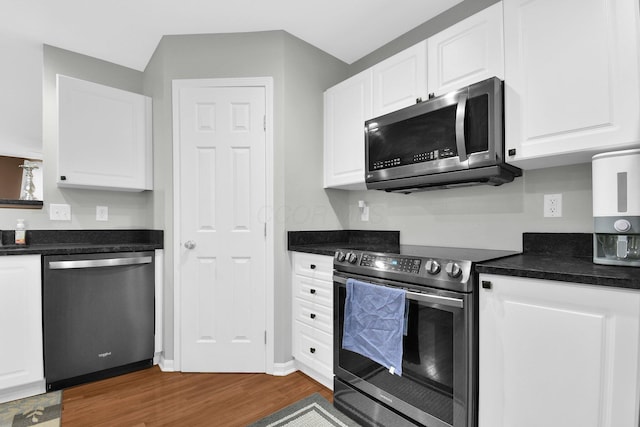 kitchen featuring white cabinets, dark wood-style flooring, dark countertops, and appliances with stainless steel finishes