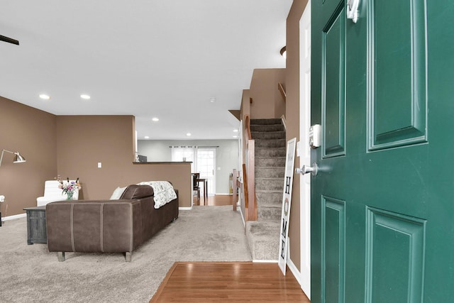 entryway featuring stairs, recessed lighting, baseboards, and light colored carpet