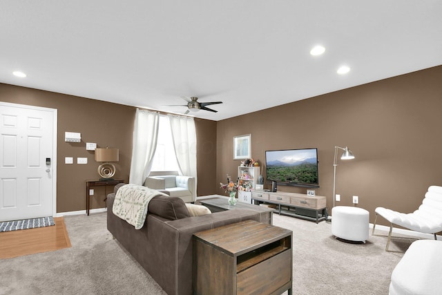 living room featuring baseboards, ceiling fan, light carpet, and recessed lighting