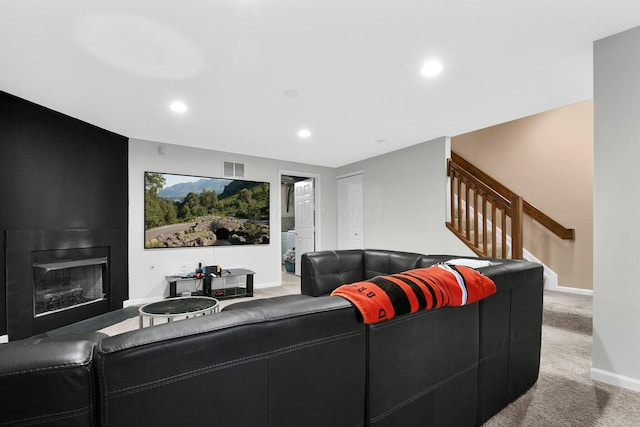 carpeted living area with a large fireplace, stairs, recessed lighting, baseboards, and visible vents