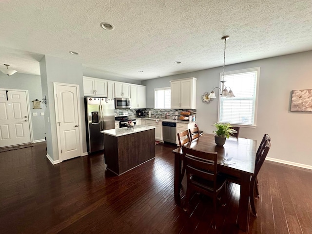 dining space featuring a textured ceiling, baseboards, dark wood-style floors, a chandelier, and recessed lighting