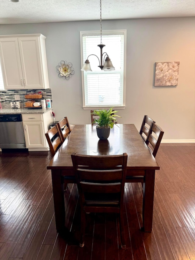 dining area featuring dark wood-style flooring and a textured ceiling