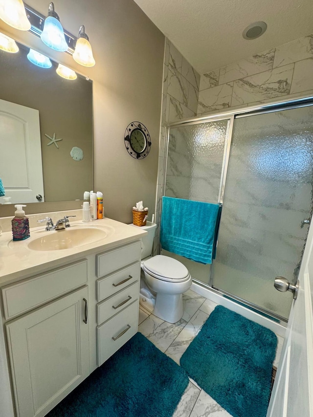 full bath with vanity, marble finish floor, toilet, and a shower stall