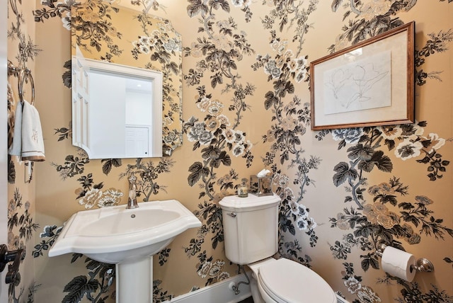 bathroom with toilet and wallpapered walls