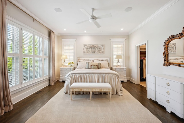 bedroom featuring a walk in closet, baseboards, ornamental molding, recessed lighting, and dark wood-type flooring