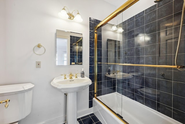 full bathroom featuring shower / bath combination with glass door, tile patterned flooring, and toilet