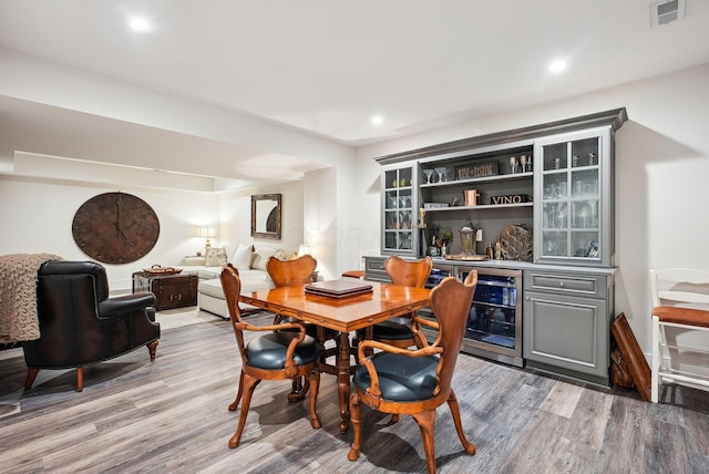 dining space featuring a dry bar, light wood-style floors, recessed lighting, wine cooler, and visible vents