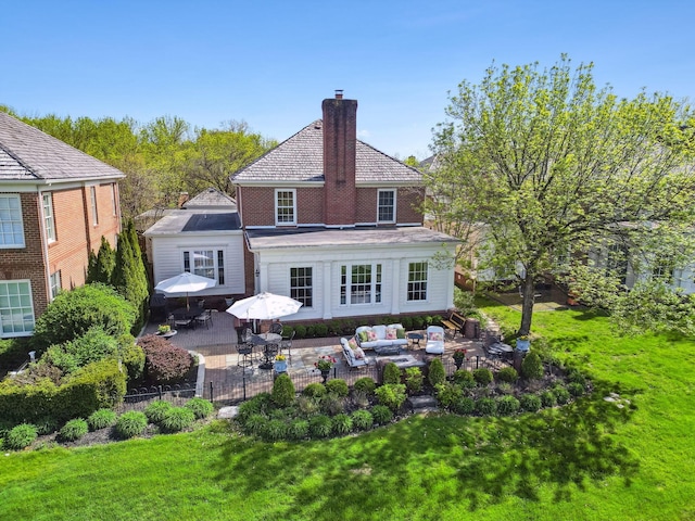 rear view of property featuring a patio, a chimney, an outdoor living space, a lawn, and outdoor dining space