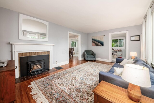 1938 W 5th Ave, Columbus, OH 43212 - living room featuring a tiled fireplace, wood finished floors, and baseboards