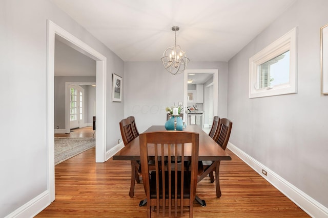 1938 W 5th Ave, Columbus, OH 43212 - dining room featuring light wood-style floors, a chandelier, and baseboards