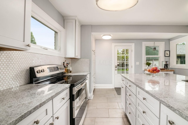 1938 W 5th Ave, Columbus, OH 43212 - kitchen featuring double oven range, decorative backsplash, white cabinets, light stone countertops, and baseboards