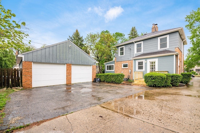 1938 W 5th Ave, Columbus, OH 43212 - view of front of house with brick siding, a garage, fence, a chimney, and an outbuilding