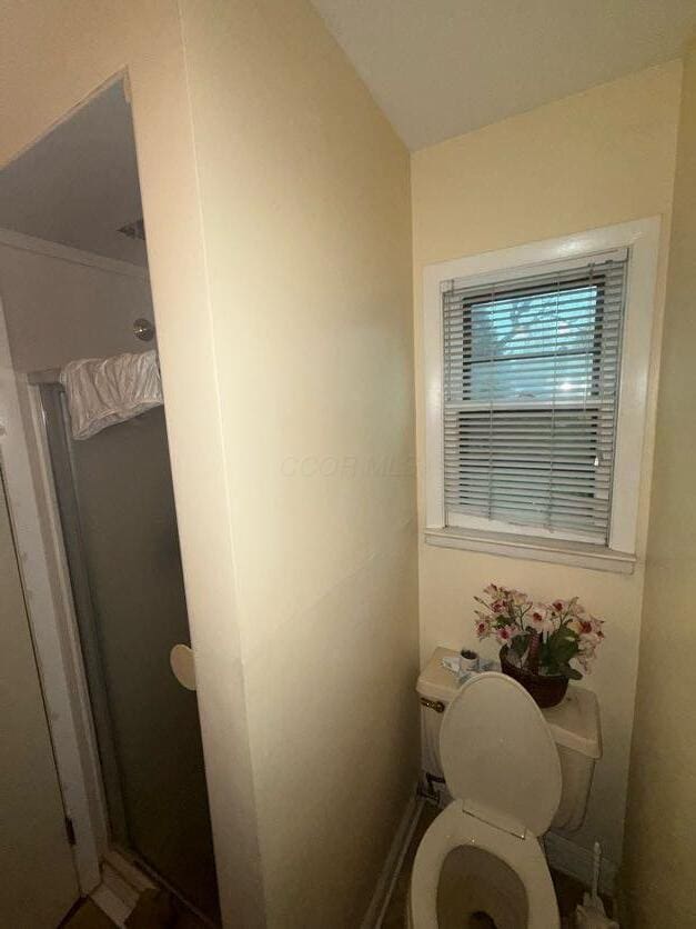 bathroom with toilet and a shower stall