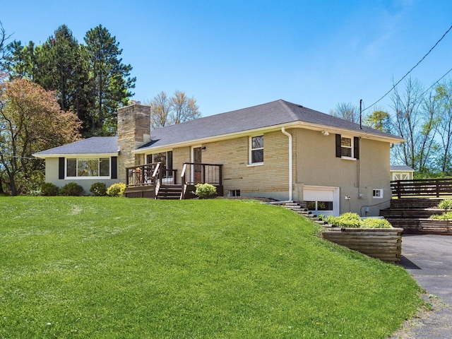 view of front of property with a front yard, a deck, a chimney, brick siding, and a shingled roof