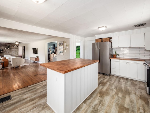 kitchen featuring visible vents, wooden counters, open floor plan, light wood-type flooring, and high end refrigerator