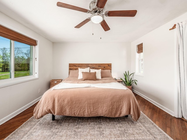bedroom with baseboards, ceiling fan, and wood finished floors
