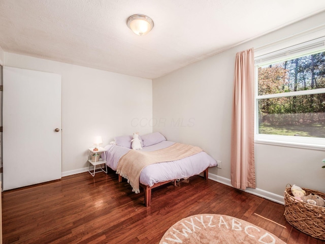 bedroom with baseboards and wood finished floors