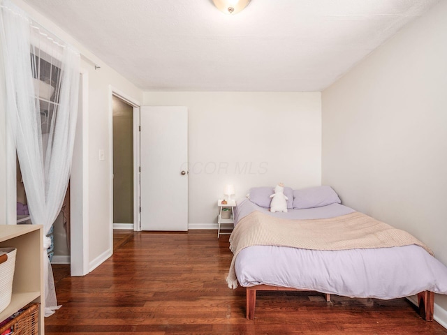 bedroom with baseboards and wood finished floors