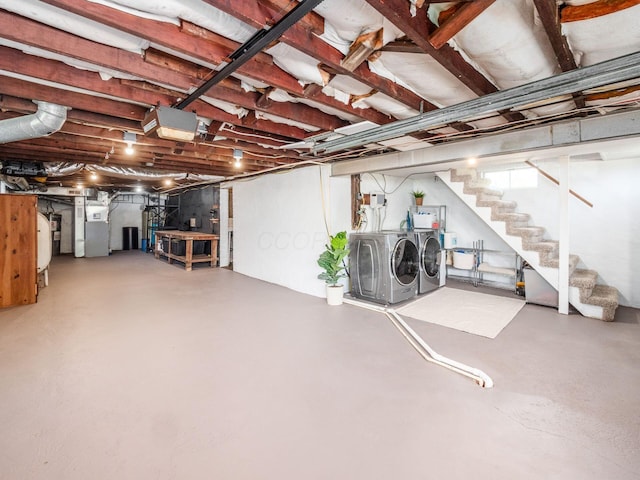 unfinished below grade area with stairway, heating unit, and washer and clothes dryer